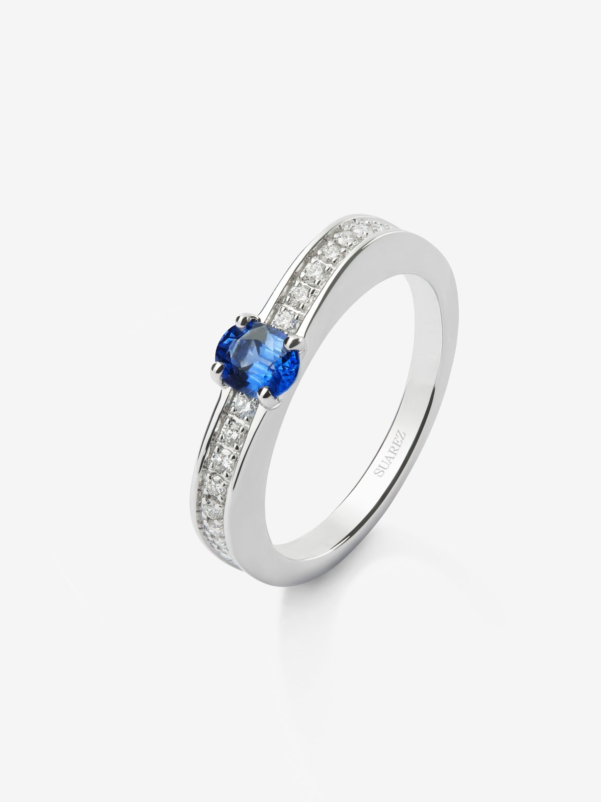 Anillo de oro blanco de 18K con zafiro azul en talla oval de 0,44 cts y 22 diamantes en talla brillante con un total de 0,16 cts