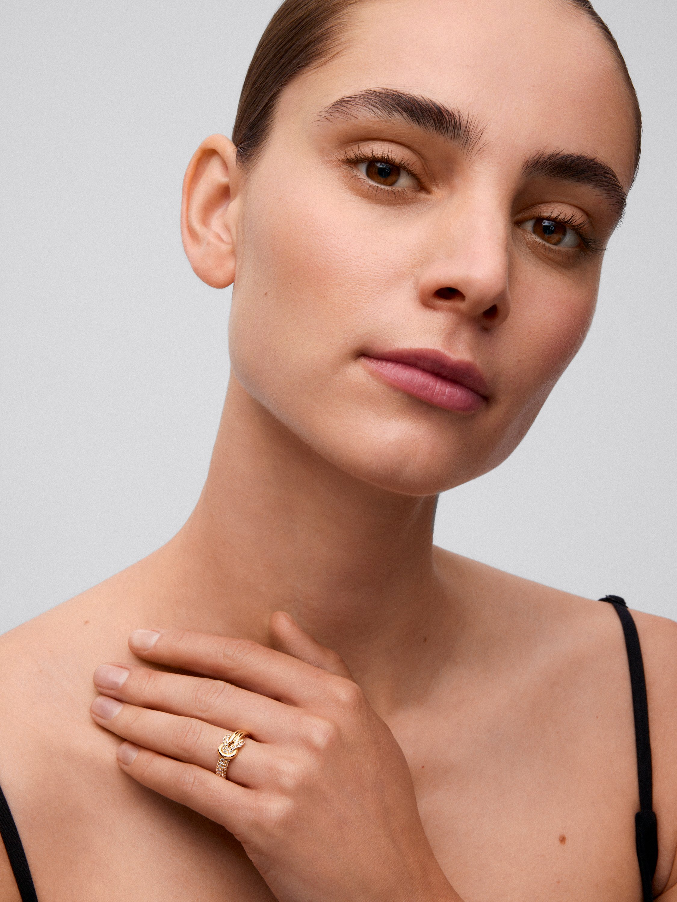 Anillo de oro amarillo de 18K con diamantes blancos en talla brillante de 0,32 cts y forma de nudo