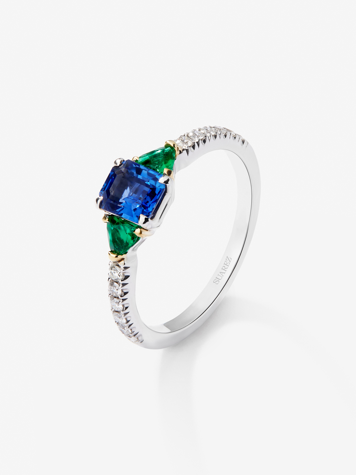 Anillo de oro blanco de 18K con zafiro azul en talla octogonal de 0,94 cts, esmeraldas verdes en talla trillon de 0,22 cts y diamantes blancos en talla brillante de 0,028 cts
