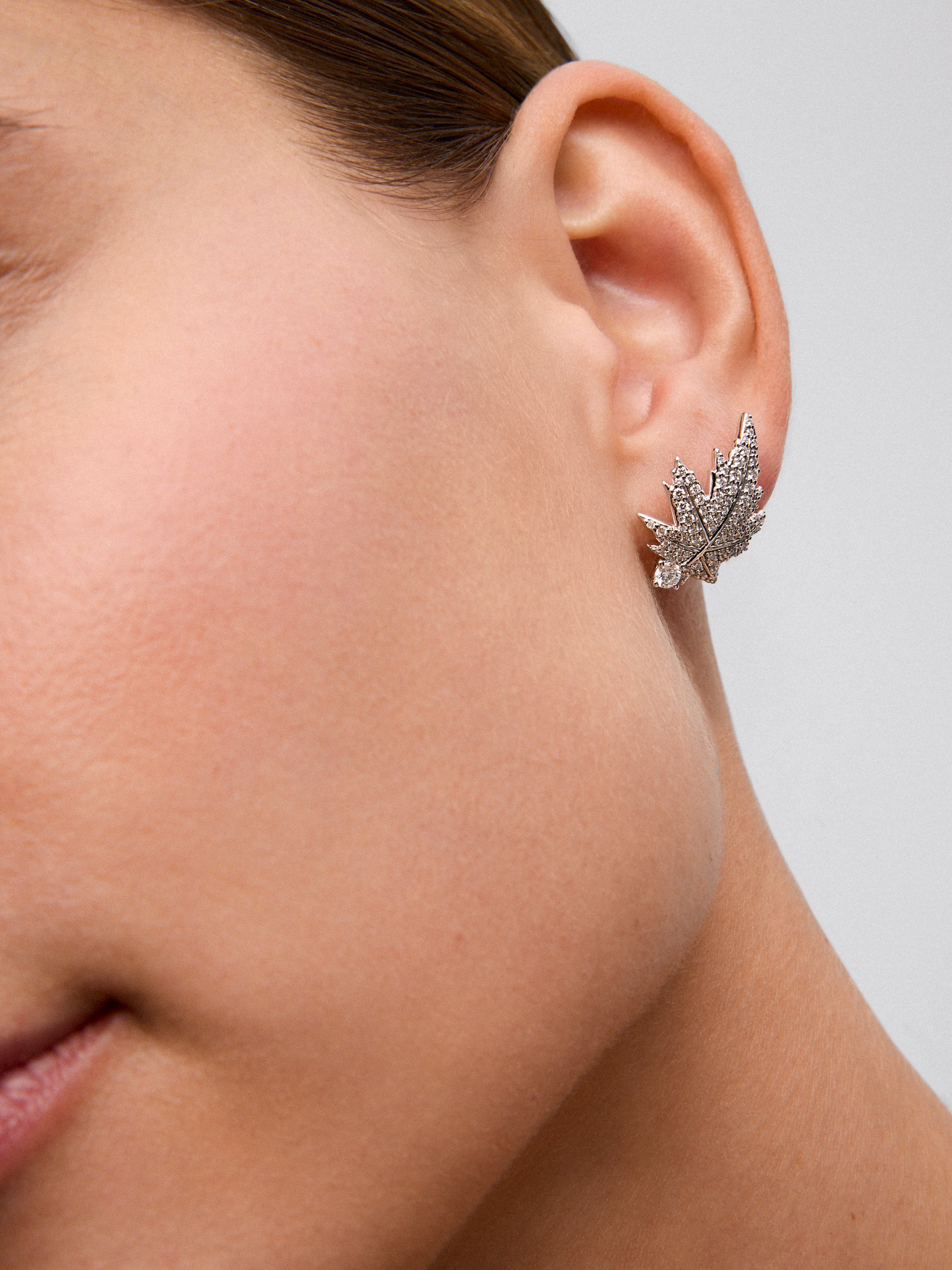 Pendientes de oro blanco de 18K con 2 diamantes centrales con un total de 0,26 cts, pavé de diamantes y forma de hoja de arce  