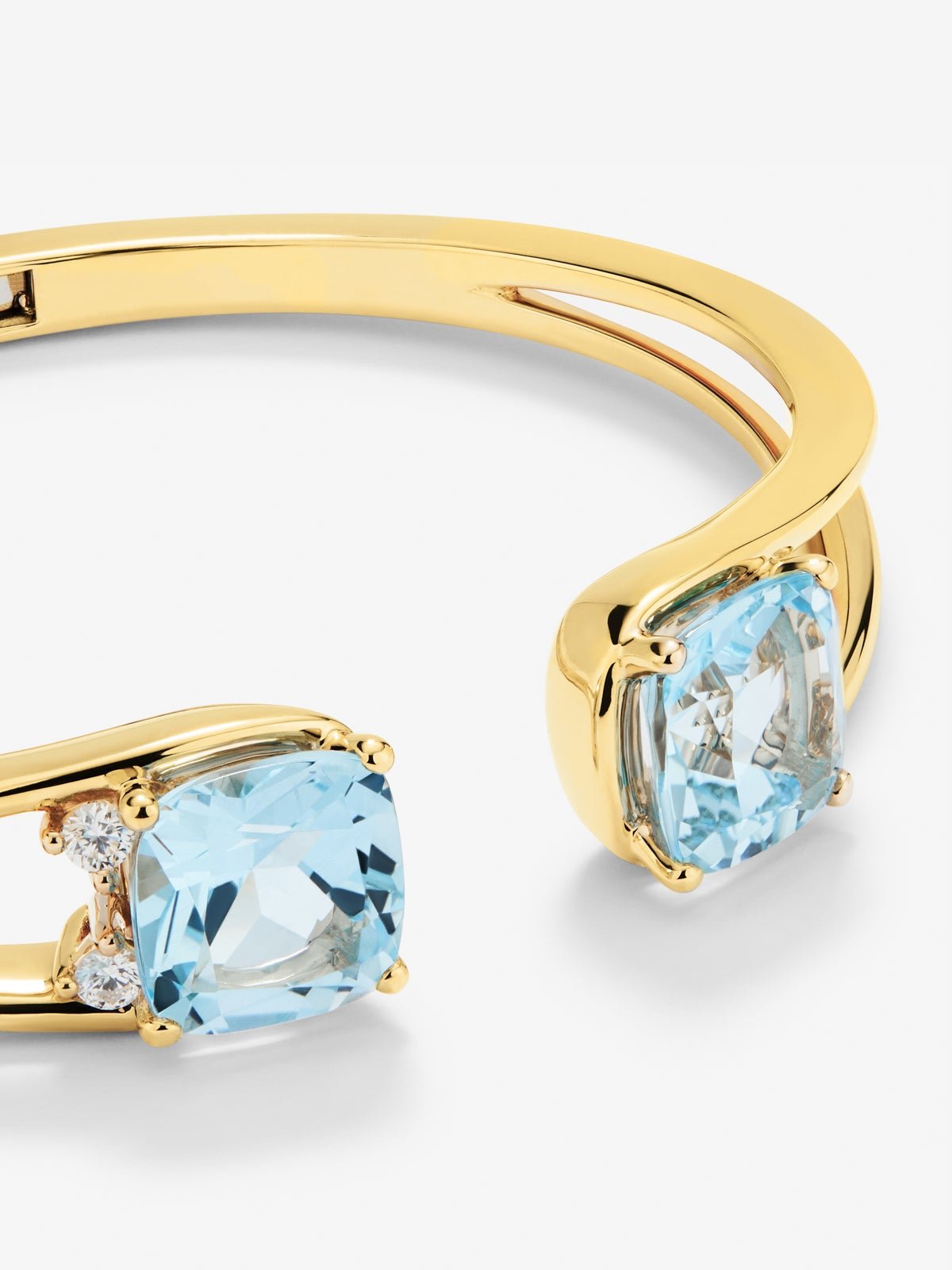 Pulsera rígida de oro amarillo de 18K con 2 topacios azul sky en talla cushion con un total de 0,12 cts
