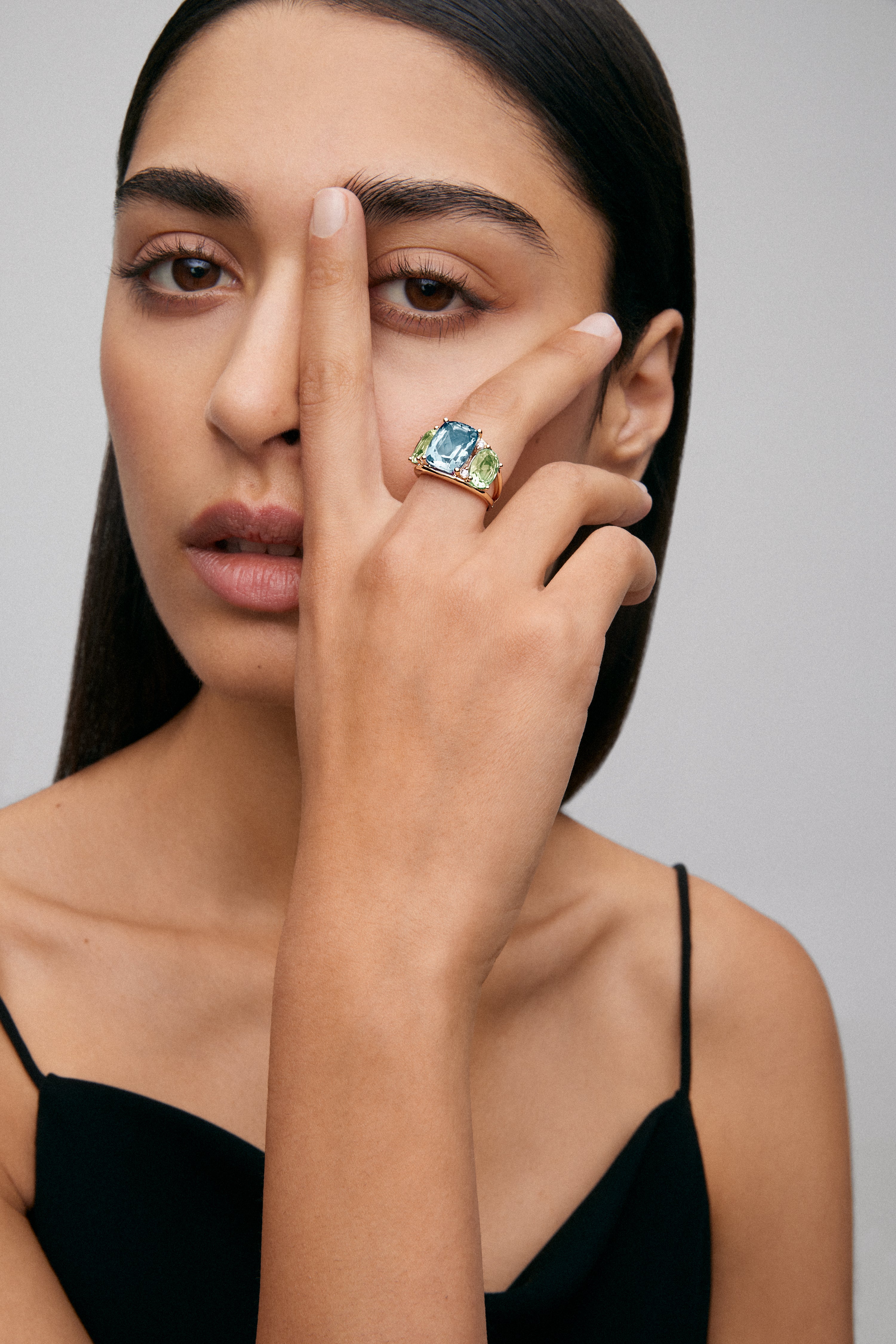 18K yellow gold ring with blue Sky Topacio in 5.5 cts Cushion size, green -sized icatists of 4.65 cts and white diamonds in a brilliant size of 0.15 cts